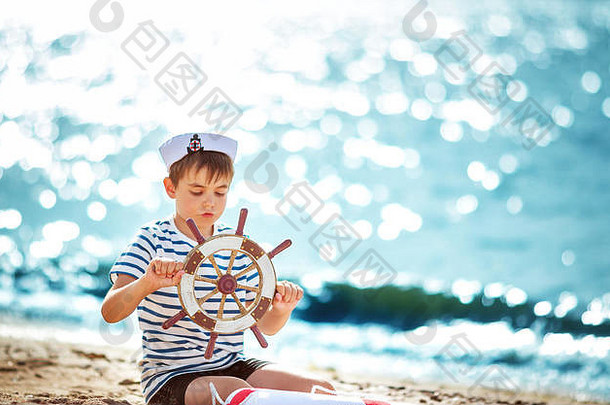 在海滩上玩方向盘的男孩