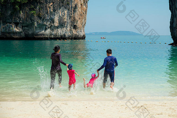 泰国普吉岛，一个快乐的亚洲家庭夏天在海滩上奔跑的照片。暑期、旅游、度假、度假概念。