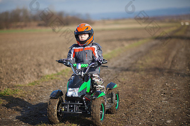 一个小男孩骑着他的电动亚视四轮车。