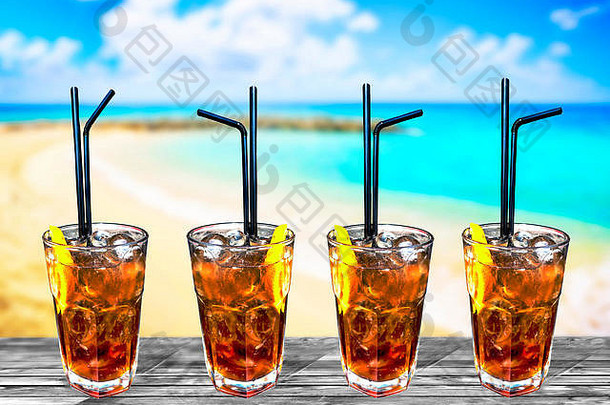 四杯古巴libre异国情调美味鸡尾酒背景海滩和绿松石海