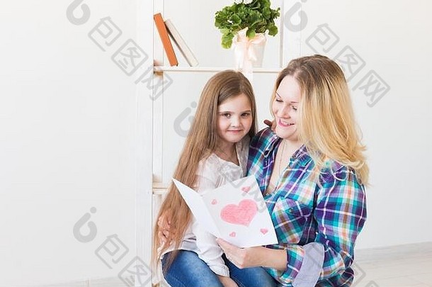 母亲节和家庭假日——母亲读女儿的贺卡。