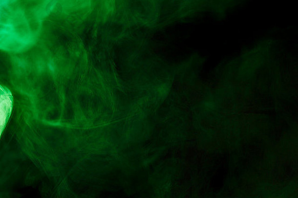 抽象绿色水烟烟在黑色背景上。使用凝胶过滤器拍摄。不健康的概念。