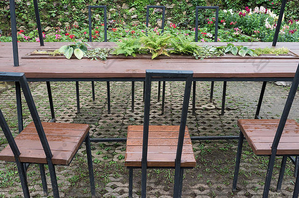 花园里的砖地上摆放着金属框架的桌子和茶具。