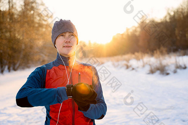 跑步者穿温暖的运动衣服耳机现代聪明的时钟