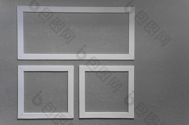 灰墙背景上三个白色相框的特写镜头