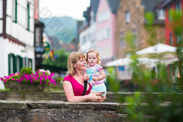 美丽的年轻女子和可爱的小女孩站在桥上欣赏着德国古老的传统城市中心