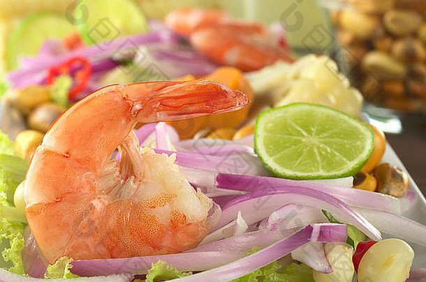 秘鲁大虾切维契：大虾配红洋葱和生菜，背面有玉米粒和酸橙片