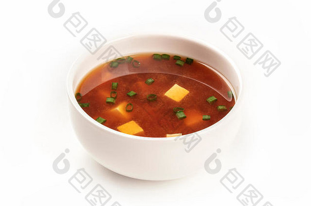 一张照片是一碗味噌汤，上面有豆腐和葱，背景为白色，并留有复印空间