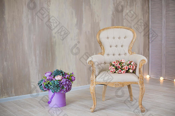 工作室室内装饰，带有浅色暖色花朵和休闲复古家具。