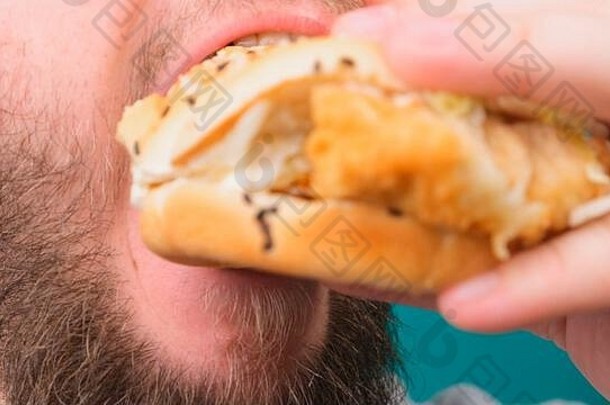 一个男人用色度键咬汉堡的特写镜头。不健康和不健康饮食的概念，高胆固醇。