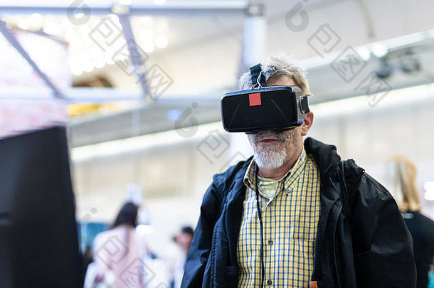 戴着虚拟现实护目镜观看虚拟现实演示的高级男子。