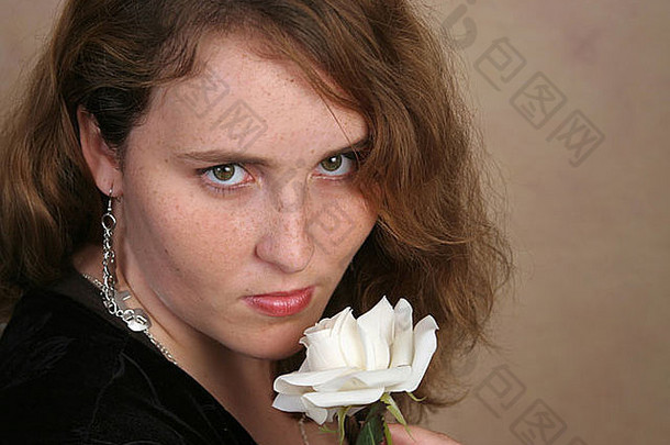 美丽的红色的头发的年轻的女人摆姿势白色玫瑰