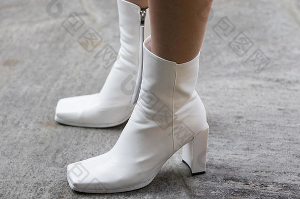 米兰，意大利——2017年9月22日：阿玛尼游行期间，模特穿着一双方尖白色靴子，在街上拍摄