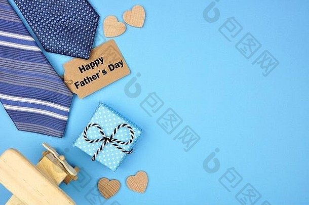 “父亲节快乐”礼物标签，蓝色背景上有礼物、领带和心形的侧边。具有空间的俯视图，
