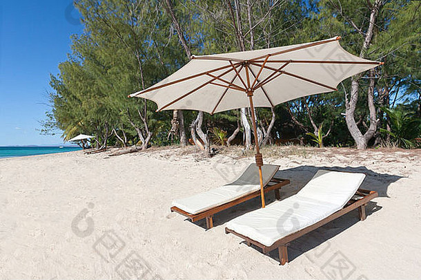 面对泻湖的白色沙滩上的躺椅和阳伞