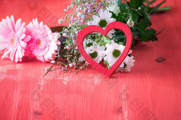 爱情<strong>主题图片</strong>，红色木桌上，红色木心支撑着一束鲜花。关系、爱情、情人节的概念
