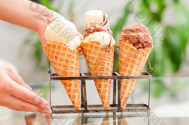 巧克力和香草冰淇淋蛋<strong>卷</strong>。手拿着装在<strong>威化</strong>杯里的冰淇淋。