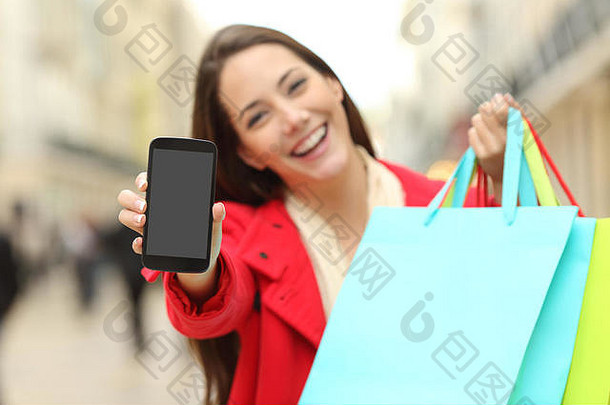 前面视图购物者持有空白购物袋显示相机聪明的电话屏幕城市背景