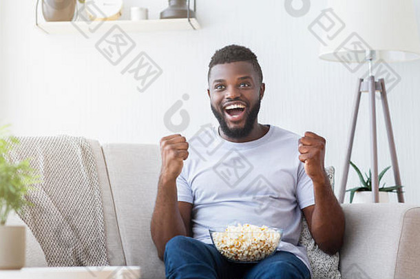 兴奋的黑人在家看电视上的体育节目