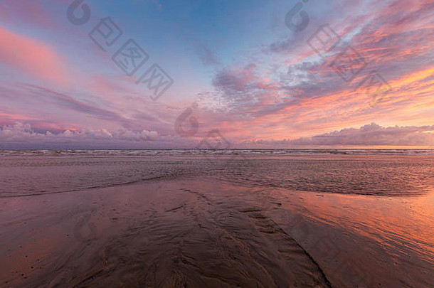 生动的粉红色的日落潮布赖顿抛海滨反映了沙子9月苏塞克斯