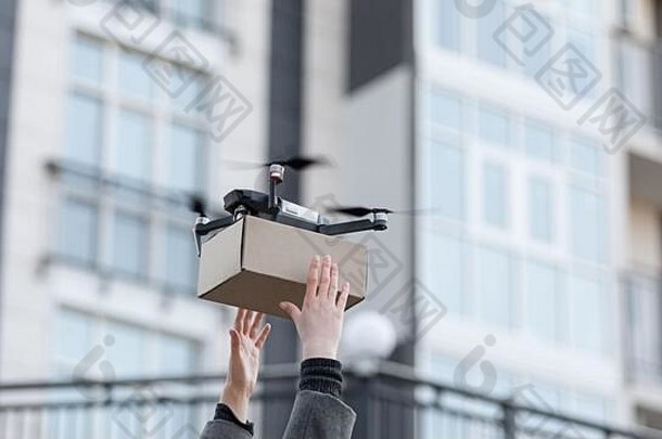 妇女携带来自quadrocopter的包裹非接触式递送
