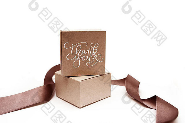 白色背景上有棕色丝带和文字“谢谢”的礼品盒