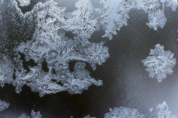 霜冻造成的窗户上的龙纹装饰物。窗户上的冰水创造了银色美丽的装饰饰品。