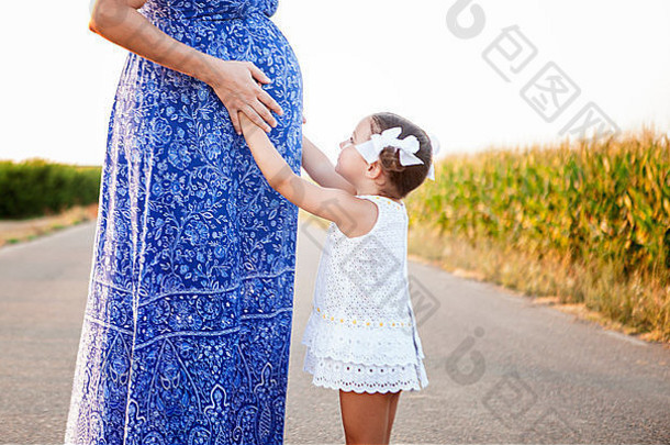 怀孕了妈妈。女儿期待新生儿哥哥国家路玉米地