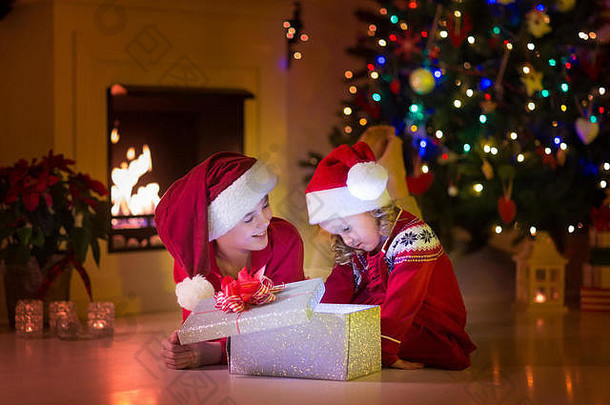 家庭圣诞节夏娃壁炉孩子们开放圣诞节礼物孩子们圣诞节树礼物盒子