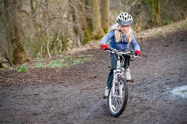 年轻的女孩骑自行车国家跟踪水平拍摄Copyspace