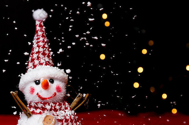 雪人在模糊的圣诞树和灯塔上的雪地上