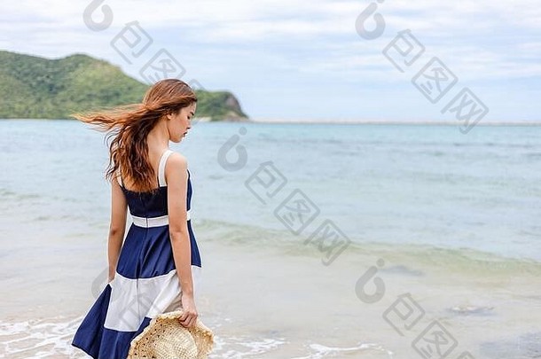 快乐的年轻女孩戴着帽子在海滩上散步。<strong>暑期旅游</strong>、度假、度假理念。