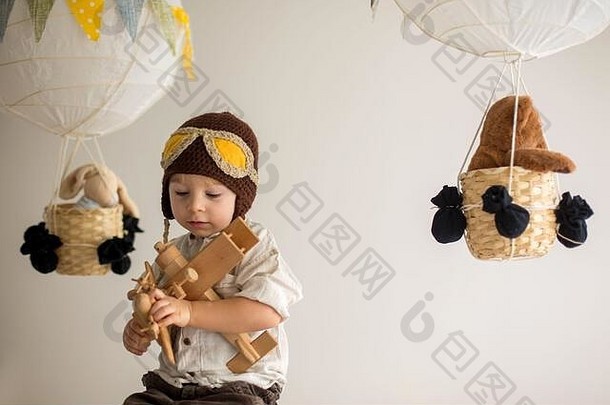 甜蜜的蹒跚学步的男孩玩飞机泰迪熊装饰空气气球玩具