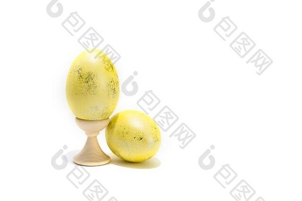 在白色背景上分离的两个彩色复活节鸡蛋。一个在支架上。
