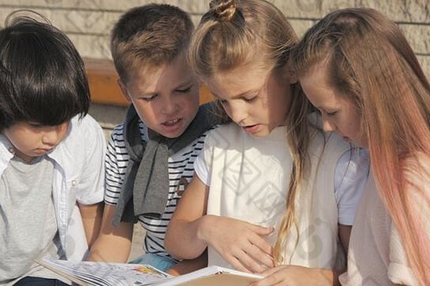 可爱的孩子在户外看书。