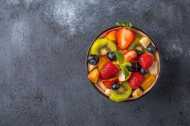 新鲜的水果沙拉成分黑暗表格健康的吃复制空间前视图