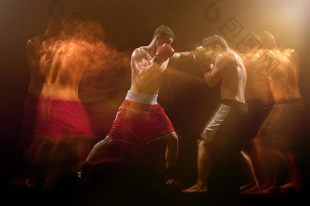 两名男拳击手在黑暗的演播室里拳击