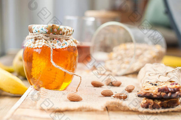 茶，坚果，蜂蜜，放在罐子里，<strong>香蕉</strong>放在靠近眼睛的木桌上。健康早餐。复古照<strong>片</strong>。