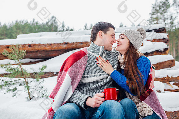 年轻的浪漫的夫妇热喝冬天森林夫妇爱