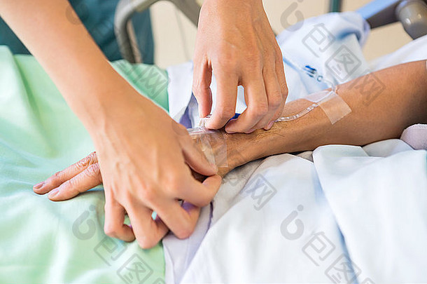 女护士在男病人手上附加静脉滴注