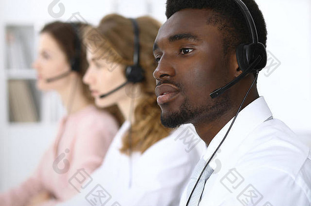 戴耳机的非洲裔美国人呼叫接线员。呼叫中心业务或客户服务理念