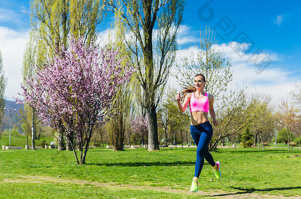 春天在公园里跑步锻炼身体的女人