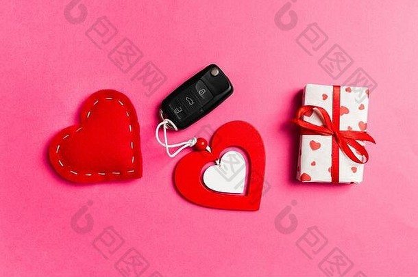 彩色背景上礼品盒、车钥匙、木制和纺织心形的俯视图。情人节的奢侈礼物。
