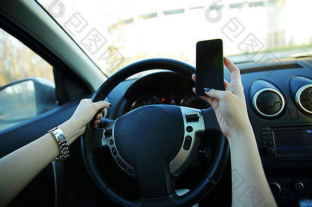 一位女商人开车上班时发短信的特写镜头
