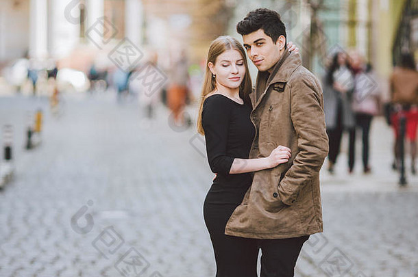 都市现代年轻情侣漫步浪漫谈天，手牵着手约会。年轻的多元文化土耳其黑发和高加索夫妇
