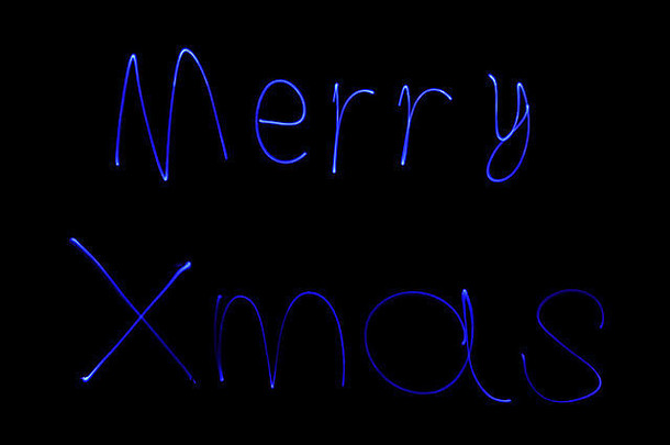晚上用蓝光拼写的圣诞快乐短信。这些信件被单独拍照，然后缝合在一起。