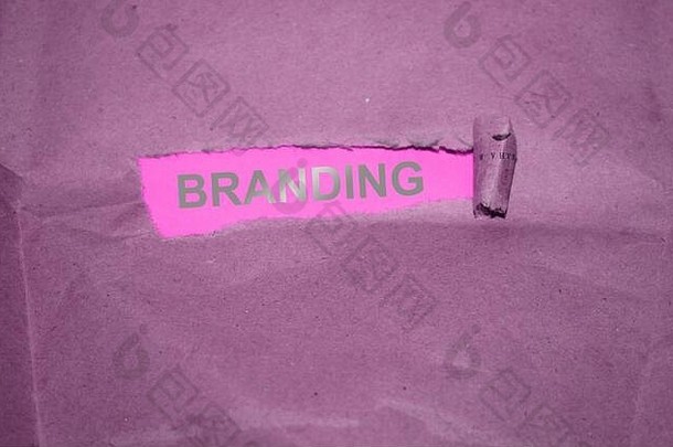 “品牌”一词写在撕破的纸上，粉红色背景上有<strong>银色字</strong>母
