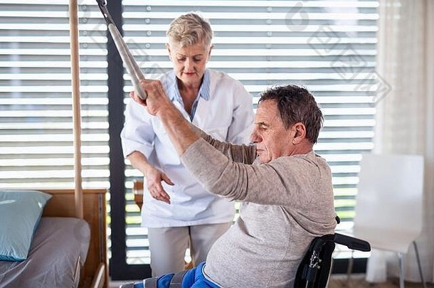 一名医护人员在医院帮助瘫痪的老年病人。