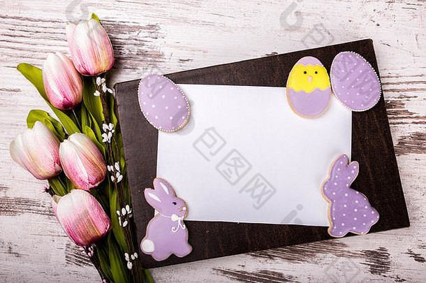 复活节姜饼饼干美丽的花束郁金香问候卡木表格鸡蛋兔子视图复制空间
