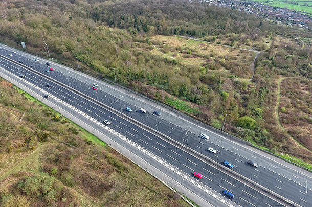 英国乡村高速公路上田野和林地之间汽车的鸟瞰图